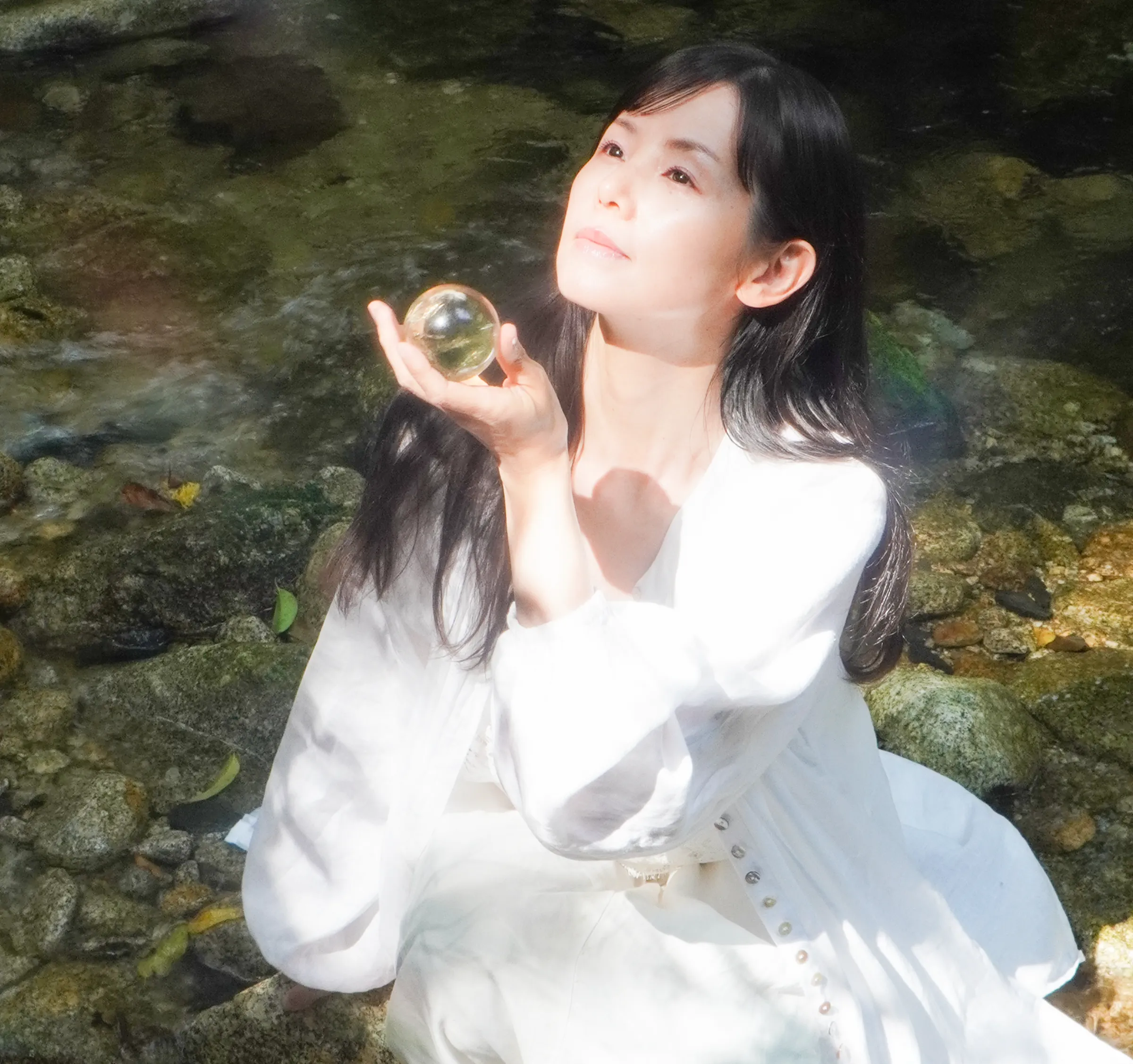 光の中に座る女性のビジュアル